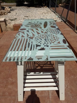 Mesa de cristal con diseño.