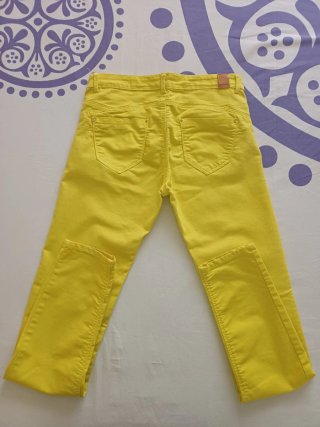 Pantalones pitillo amarillos, de tiro medio.