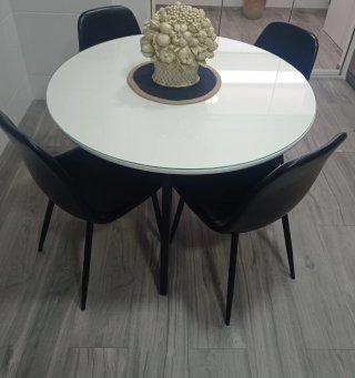 Mesa redonda blanca con 4 sillas negras
