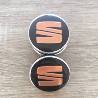 TAPABUJES SEAT 56mm NEGROS CON EMBLEMA COBRE