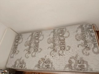 Cama individual  y cama auxiliar beige.