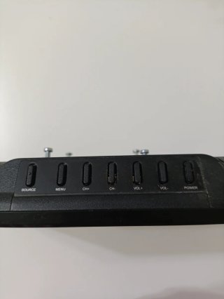 Televisor Nevir con mando a distancia y cargador.