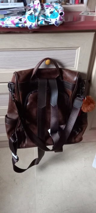 Mochila de piel marrón con pompón naranja
