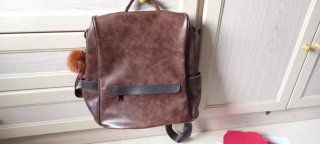 Mochila de piel marrón con pompón naranja