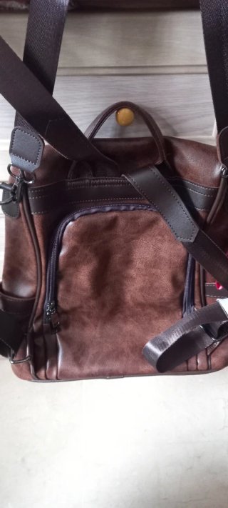 Mochila de piel marrón con pompón naranja