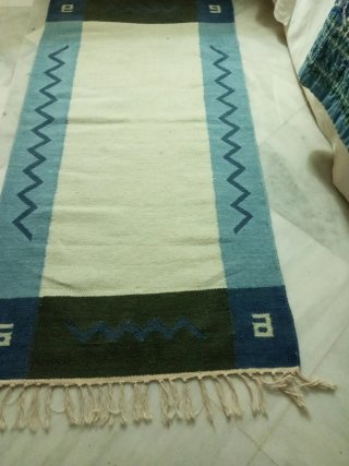 Alfombra lana crema y azul con cenefa.