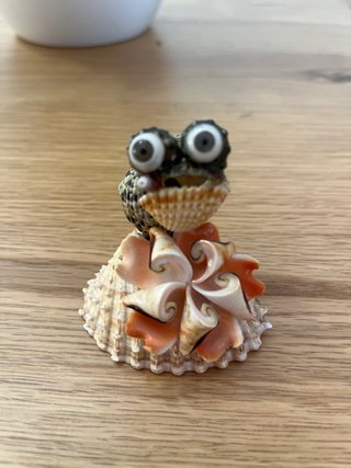 Pongo. Figura rana con puro de conchas marinas