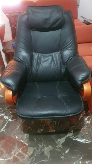 Sillón negro con reposapiés de madera