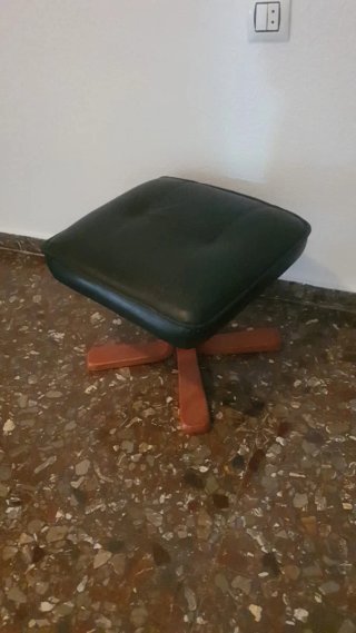 Sillón negro con reposapiés de madera