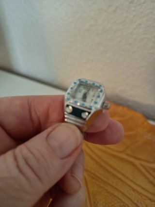Anillo con reloj plateado y detalles azules