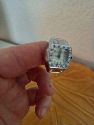 Anillo con reloj plateado y detalles azules