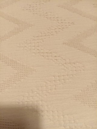 Cubre pies de cama beige con diseño zigzag