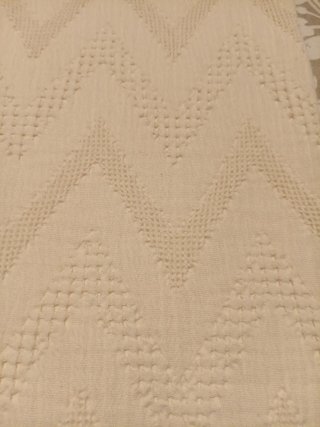 Cubre pies de cama beige con diseño zigzag