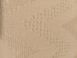 Cubre pies de cama beige con diseño zigzag