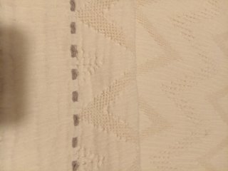 Cubre pies de cama beige con diseño zigzag