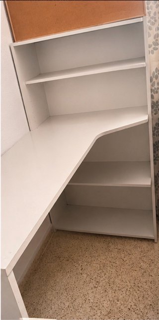 Escritorio blanco con estanterías.