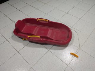 Trineo rojo con asas amarillas