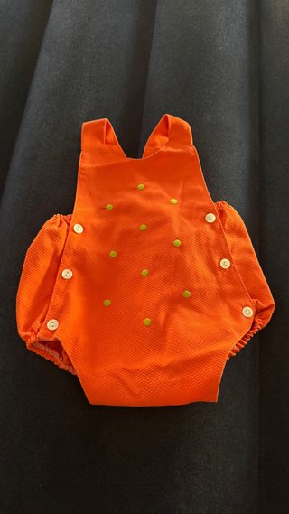 Ropa de bebé naranja con puntos verdes