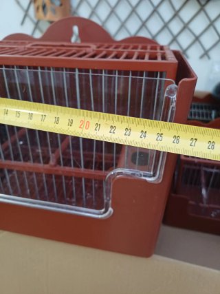 Jaula para pájaros marrón con plástico