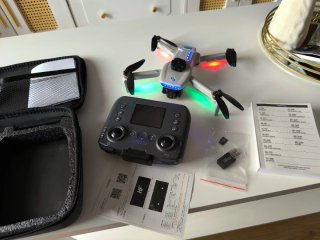 Dron gris con cámara, tres baterías y accesorios