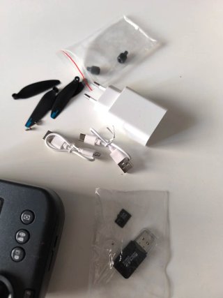Dron gris con cámara, tres baterías y accesorios