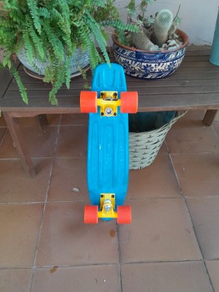 Penny board azul con ruedas naranjas