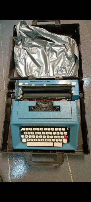 Máquina de escribir antigua azul con maletín