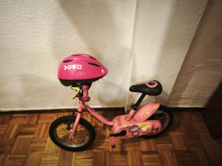 Bicicleta infantil rosa con casco