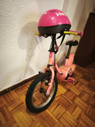 Bicicleta infantil rosa con casco