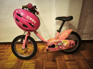 Bicicleta infantil rosa con casco