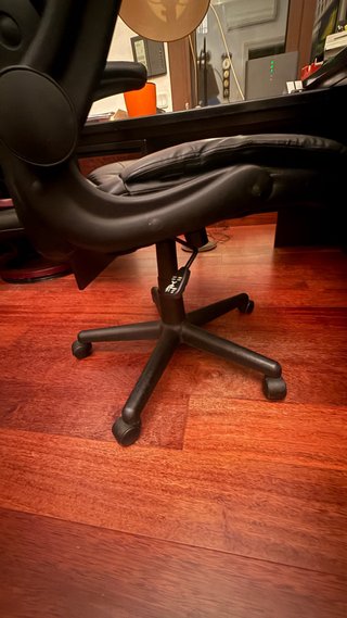 Sillón de oficina negro con ruedas y reposabrazos
