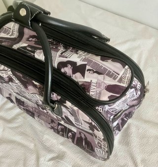 Maleta de viaje con estampado de periódico