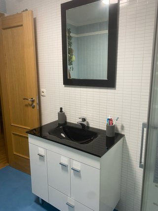 Mueble de baño con espejo, lavabo y grifo