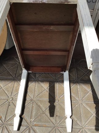 Mesa auxiliar de madera blanca.