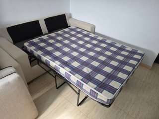 Sofá cama y sillón beige.