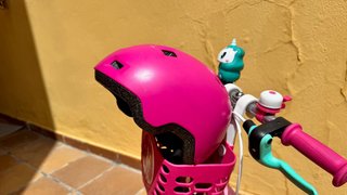 Bicicleta infantil rosa con casco y ruedines