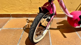Bicicleta infantil rosa con casco y ruedines