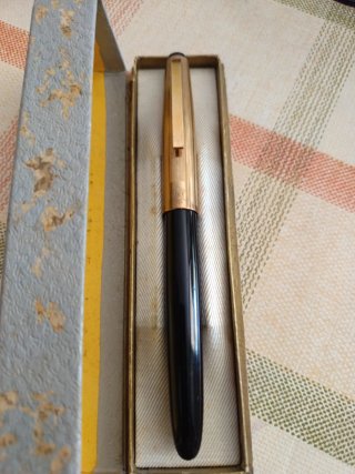 Vieja pluma bañada en oro