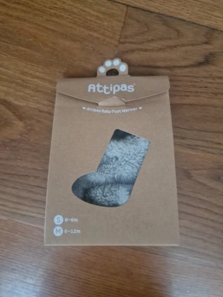 Calentadores de porteo marca Attipas color gris.