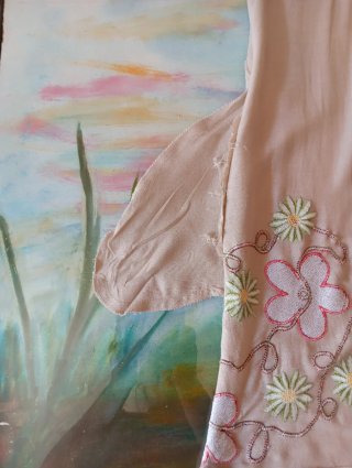 Vestido beige con bordado floral morado y verde.
