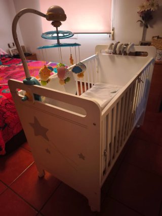 Cuna de bebé blanca con móvil