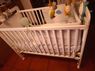 Cuna de bebé blanca con móvil