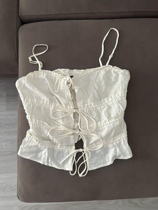 Top blanco con volantes y lazada