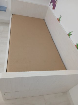 Cama infantil con estampado de dinosaurios.