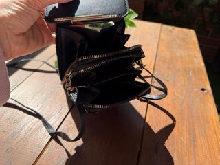 Bolso monedero negro con pantalla táctil.
