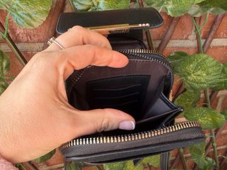 Bolso monedero negro con pantalla táctil.