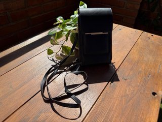 Bolso monedero negro con pantalla táctil.