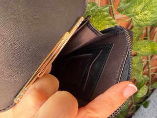 Bolso monedero negro con pantalla táctil.