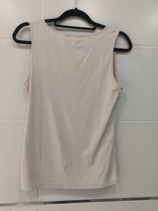 Top sin mangas color rosa pálido, cuello redondo.