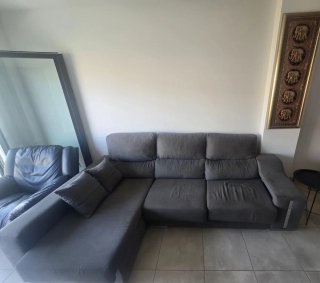 Sofá sheslong gris, sillón y vitrina de madera